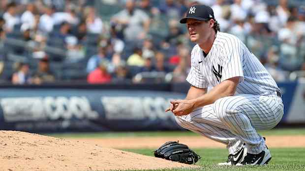 Yankees pitcher Gerrit Cole crouches beside the mound